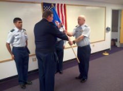 Col Toby Wall (center) passes the Squadron guidon to Lt Ron Watkins at the February 5, 2015 Change-in-Command ceremony.