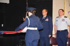 Gen Scanlan and C/Col Waters stand at attention while the flag is folded. 