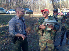 Ground Team Leader, Maj Bohler, interviews Park Ranger Tony DeSantis to obtain information about the missing person.